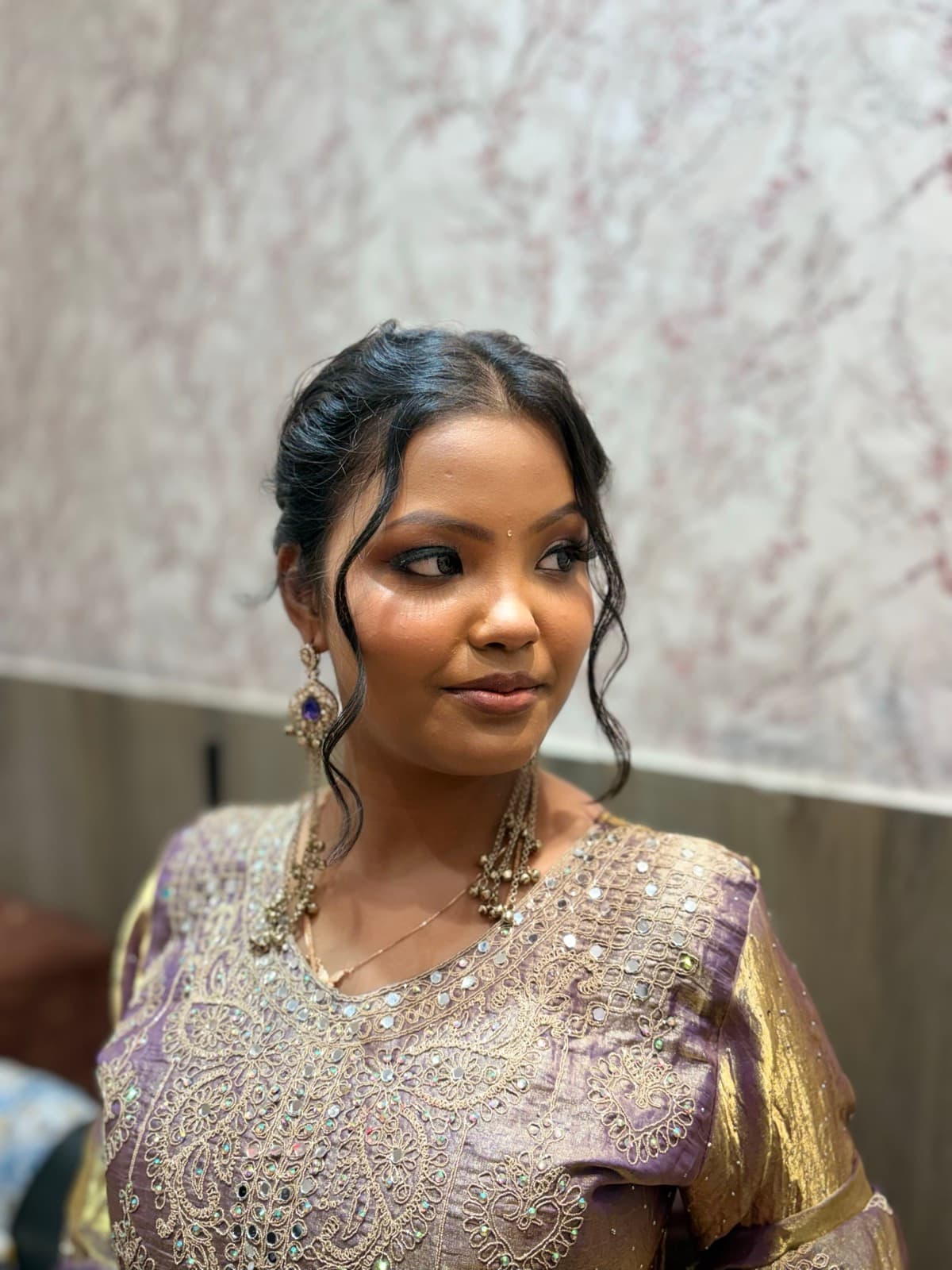 Soft glam bridal makeup with smokey eyes on a client wearing a lavender and gold embroidered lehenga