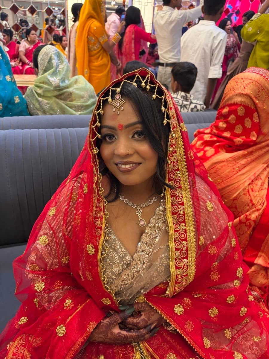 Engagement look with dewy skin finish, gold headpiece and diamond necklace on a bride in a red banarasi outfit